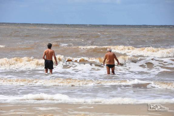 O Rodrigo e seu pai enfrentam as águas do Rio da Prata na praia de Pocitos, em Montevideo, no Uruguai